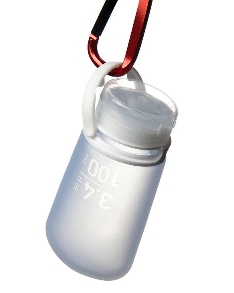 A translucent gray soft travel bottle made of silicone with a white cap and carabiner clip from gotoob+ 3 pack