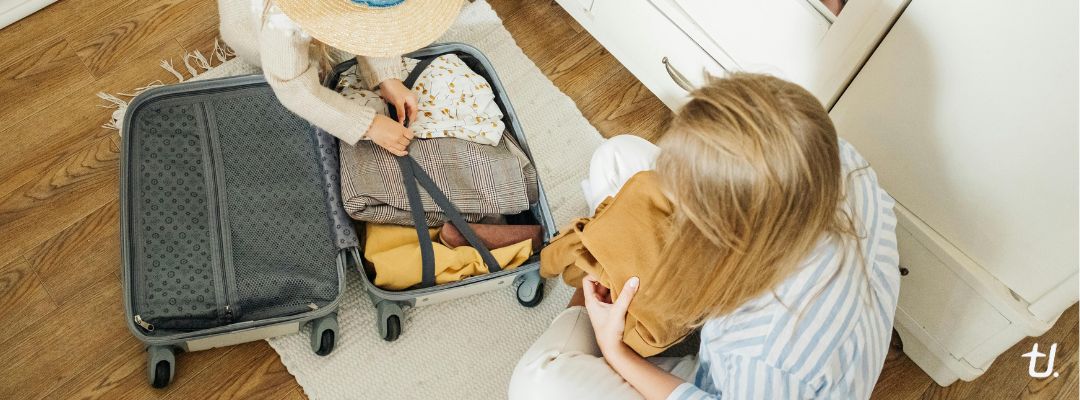 Open carry-on suitcase packed with clothes and travel essentials for a seven-day trip