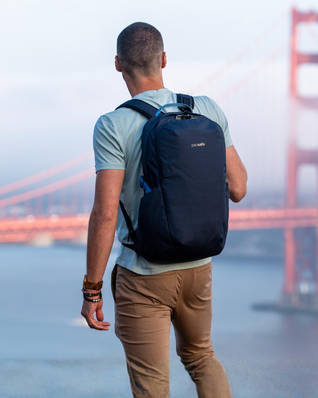Man with a Pacsafe V Tour 26L Anti-Theft 16" Laptop Backpack standing in front of the Golden Gate Bridge