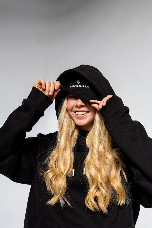 Person wearing a black travel hoodie with built in eye mask