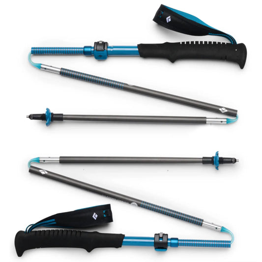 Blue and black adjustable black diamond distance carbon trekking poles with textured grips and carrying strap in desert sky