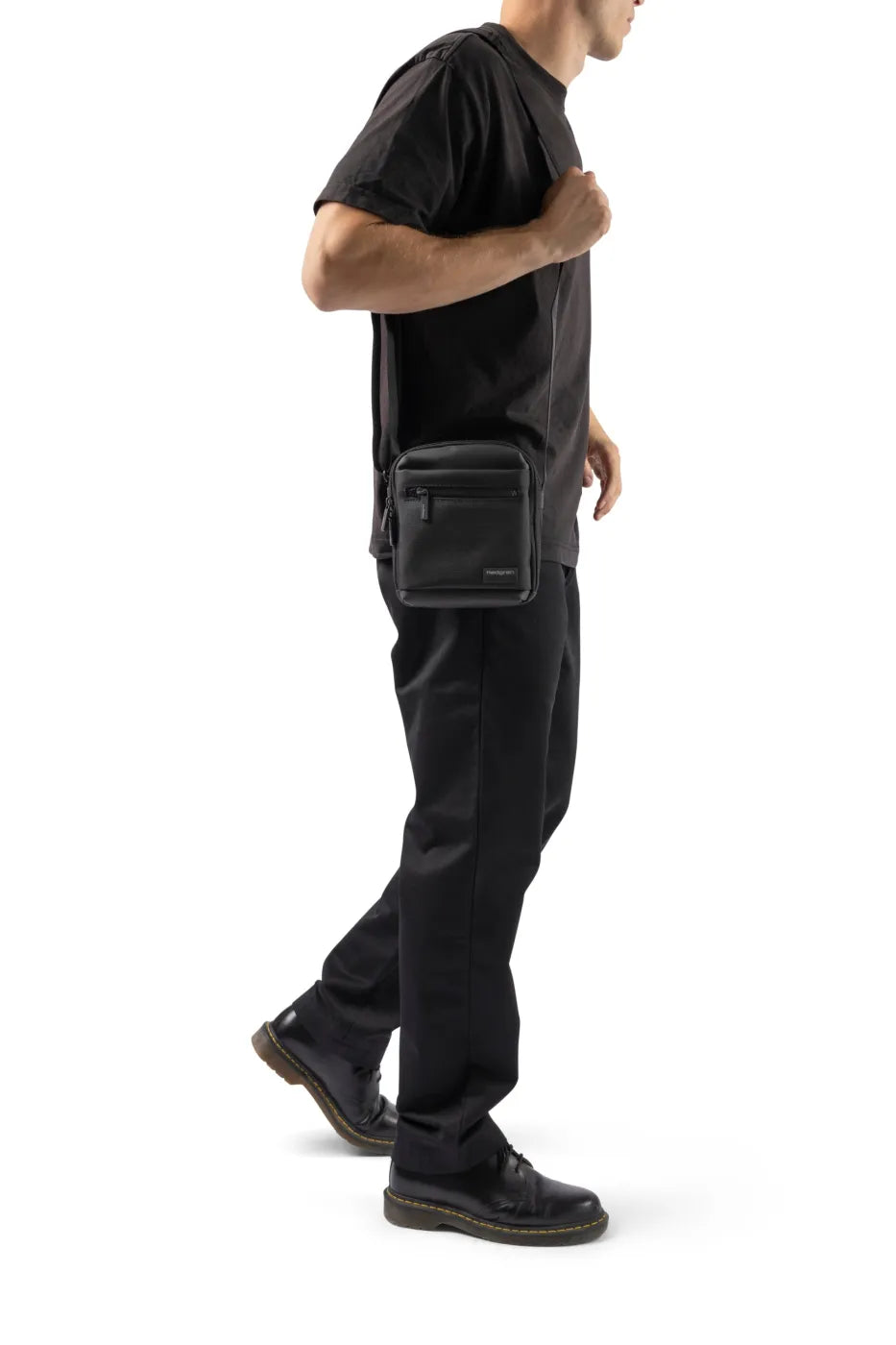 Hedgren APP Men's Vertical Crossover 7" Tablet Pouch with RFID in Black, worn crossbody by a man in a black tee, seen from the side