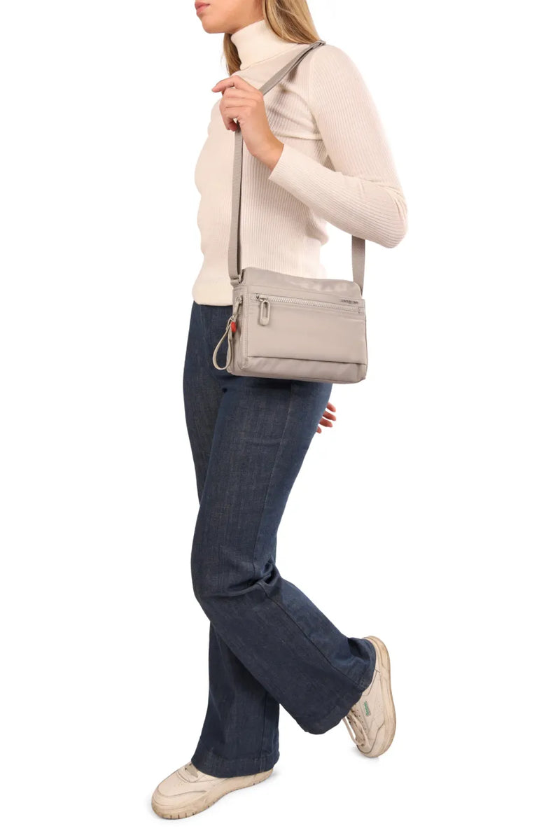 Hedgren EYE Crossbody Bag with RFID Pocket in Black, worn crossbody at the hip by a woman in a cream roll neck and jeans