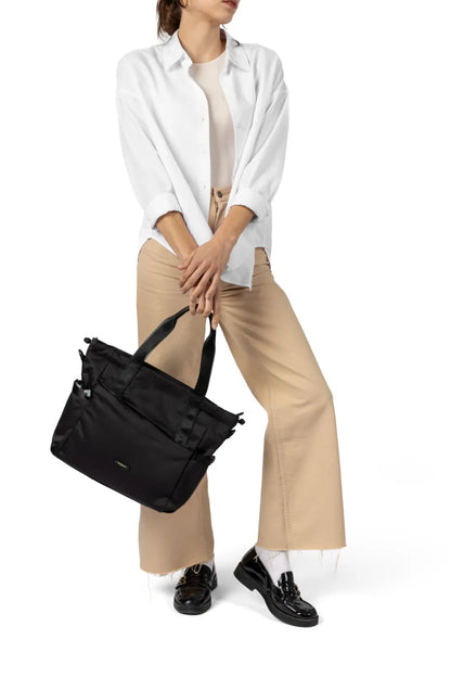 Hedgren GALACTIC Shoulder Bag / Tote in Green Milieu, carried by its top handles at the side of a woman in a white shirt