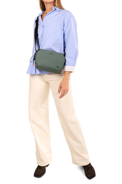 Hedgren KOSHO Medium Crossover Shoulder Bag in Vulcan Blue, worn crossbody at the waist over a blue shirt
