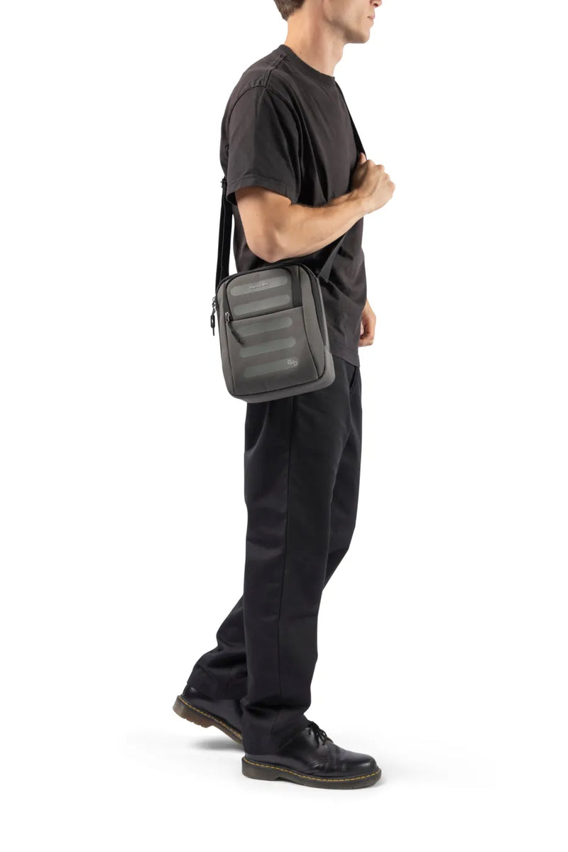 Hedgren RELAX Medium Vertical Crossbody Bag with RFID Pocket in Peacoat Blue, worn crossbody by a man in a dark tee, seen from the side