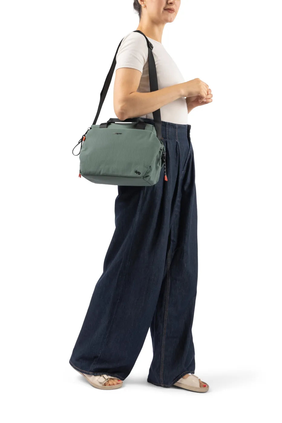Hedgren TOMOKO Handbag in Orchid Ice, carried on the shoulder by a woman in a white tee and wide denim trousers