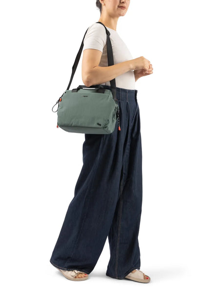 Hedgren TOMOKO Handbag in Orchid Ice, carried on the shoulder by a woman in a white tee and wide denim trousers