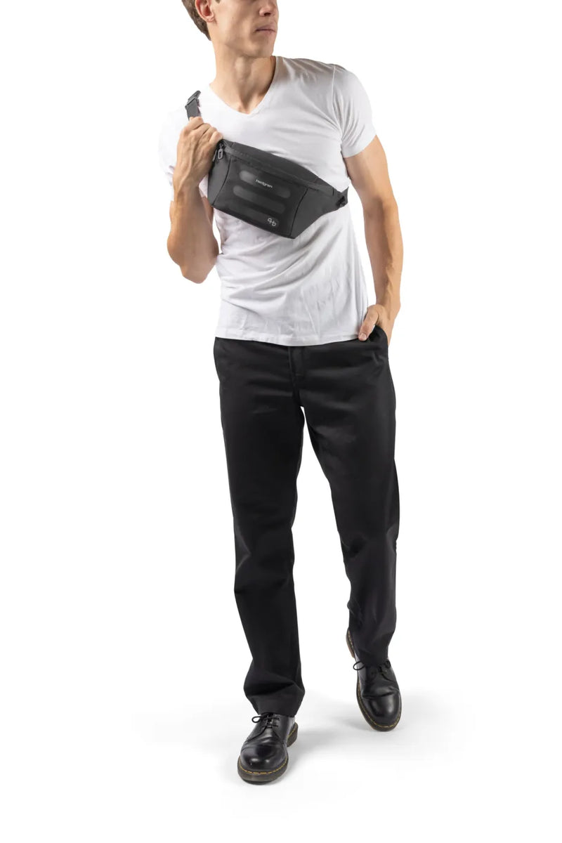 Hedgren VISIT Waistbag with RFID in Grey Green, worn across the chest by a man in a white tee
