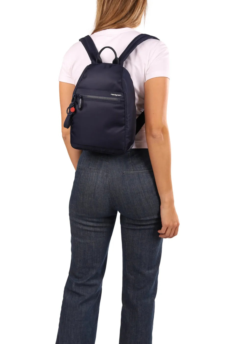 Hedgren VOGUE Small Backpack in Dahlia Red, worn on both shoulders over a pale tee and jeans, seen from behind