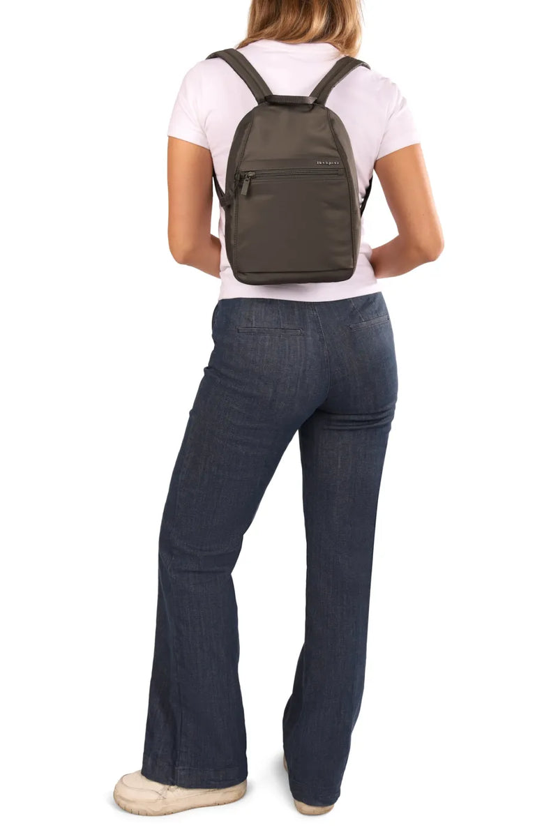 Hedgren VOGUE Small Backpack in Dahlia Red, worn on both shoulders by a woman in a pale tee and jeans, seen from behind