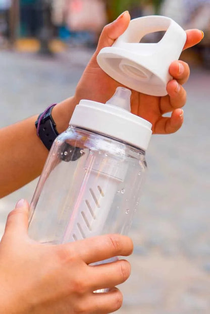 LifeStraw Go 2.0: a clear LifeStraw Go bottle with its lid twisted off on a city street