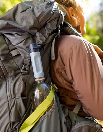 LifeStraw Peak Solo Water Filter: a LifeStraw Peak Solo clipped beside a bottle on a hiker's backpack