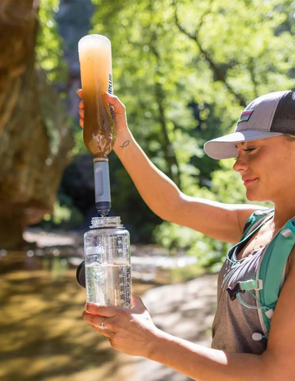 LifeStraw Peak Solo Water Filter: a hiker filtering creek water through a LifeStraw Peak Solo into a clear bottle