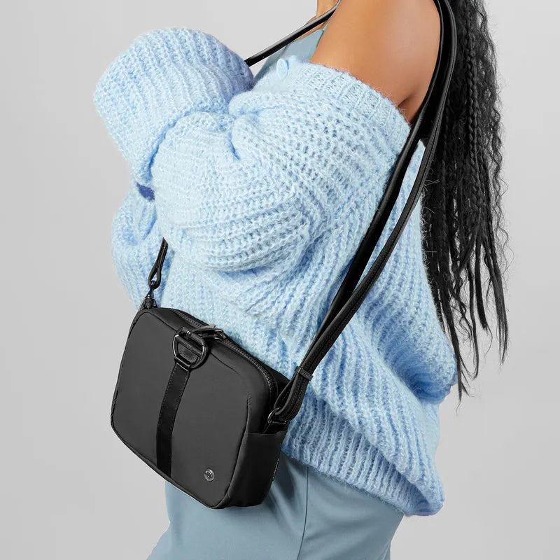 woman holding a Pacsafe Citysafe CX Econyl Anti-Theft Square Crossbody Bag - Black around her shoulder