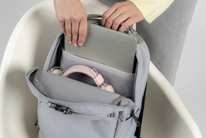 Pacsafe V City 20L Anti-Theft 16" Laptop Backpack in Digital Grey, a laptop being lowered into the padded compartment