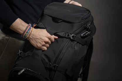 Pacsafe Venturesafe EXP35 Anti-Theft 35L Travel Backpack in Black, the top flap being unclipped from the body of the pack