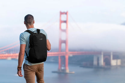 Pacsafe Vibe 25 - Anti-Theft 25L Laptop Daypack in Jet Black, worn on both shoulders by a man looking out at the Golden Gate Bridge