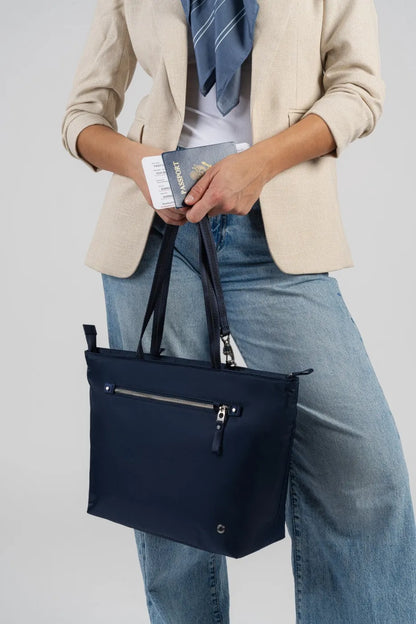 Pacsafe W Anti-theft Carryall 13" Laptop Tote in Navy, a passport and boarding pass being lifted from the bag at the hip