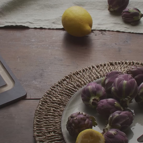 Victorinox Swiss Classic foldable paring knife in red unfolding beside artichokes and a lemon, then red, green and black knives laid on moss with sliced apples