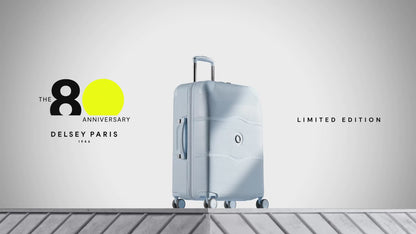 Delsey Chatelet Air 2.0 80th anniversary suitcase in light blue: dual-density wheels, the double-layer zip teeth and lock, the blue patterned deluxe lining, then the case on a stone plinth
