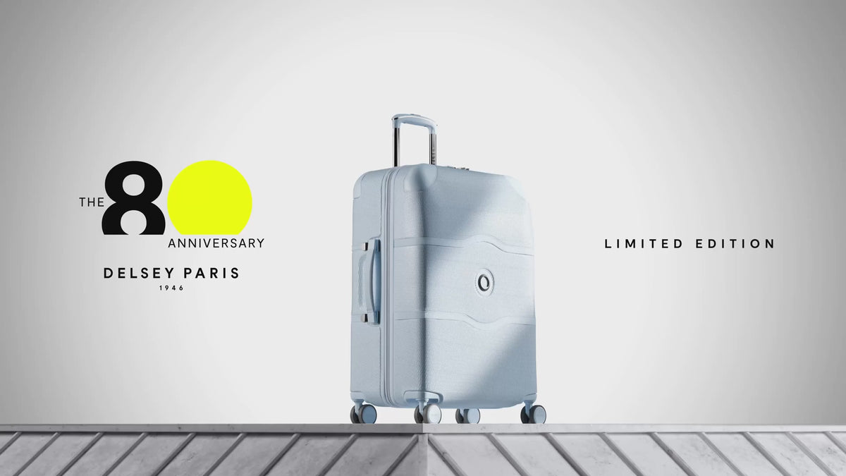 Delsey Chatelet Air 2.0 80th anniversary suitcase in light blue: dual-density wheels, the double-layer zip teeth and lock, the blue patterned deluxe lining, then the case on a stone plinth