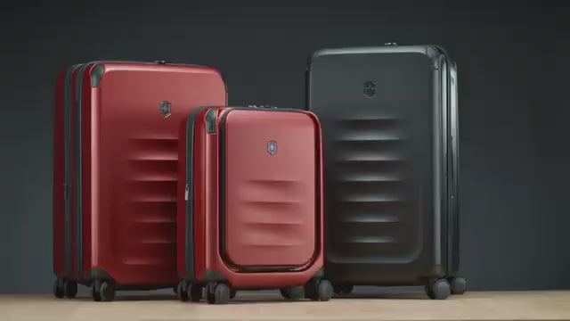 Victorinox Spectra 3.0 suitcases in red and black in a studio: the ribbed polycarbonate shell, the front-opening laptop pocket, the expandable interior packing space and the trolley handle