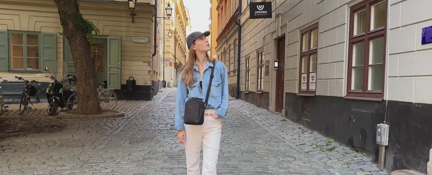 Pacsafe V Companion Crossbody worn on a cobbled old town street