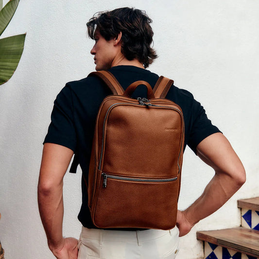 sharp dressed man with a Samsonite Classic Leather 14.1" Laptop Backpack on his back 
