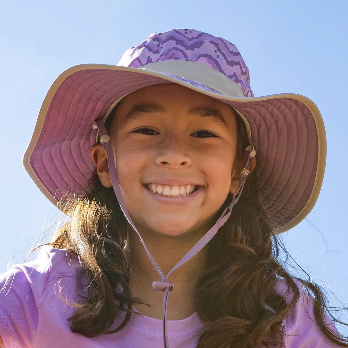 A girl wearing a Sunday Afternoons Kids Clear Creek Boonie Hat