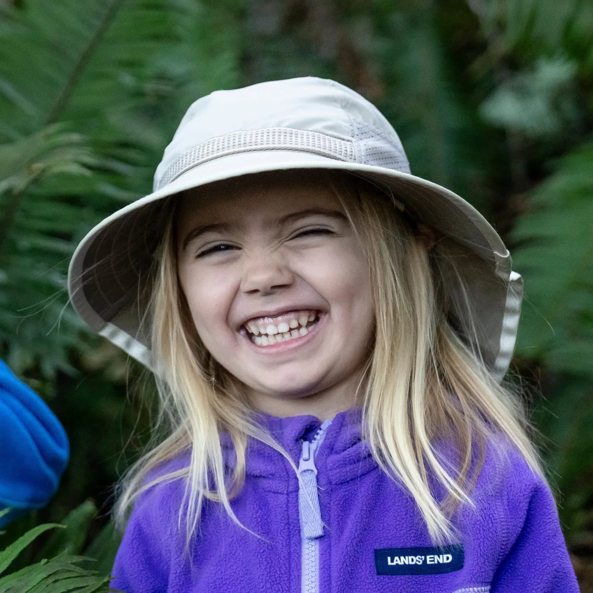 A girl wearing a Sunday Afternoons Kids Play Hat outdoors
