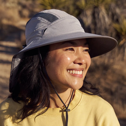 A woman wearing a Sunday Afternoons Ultra Adventure Hat in Pumice