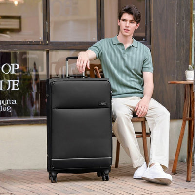 man sits at a cafe with a Tosca large suitcase